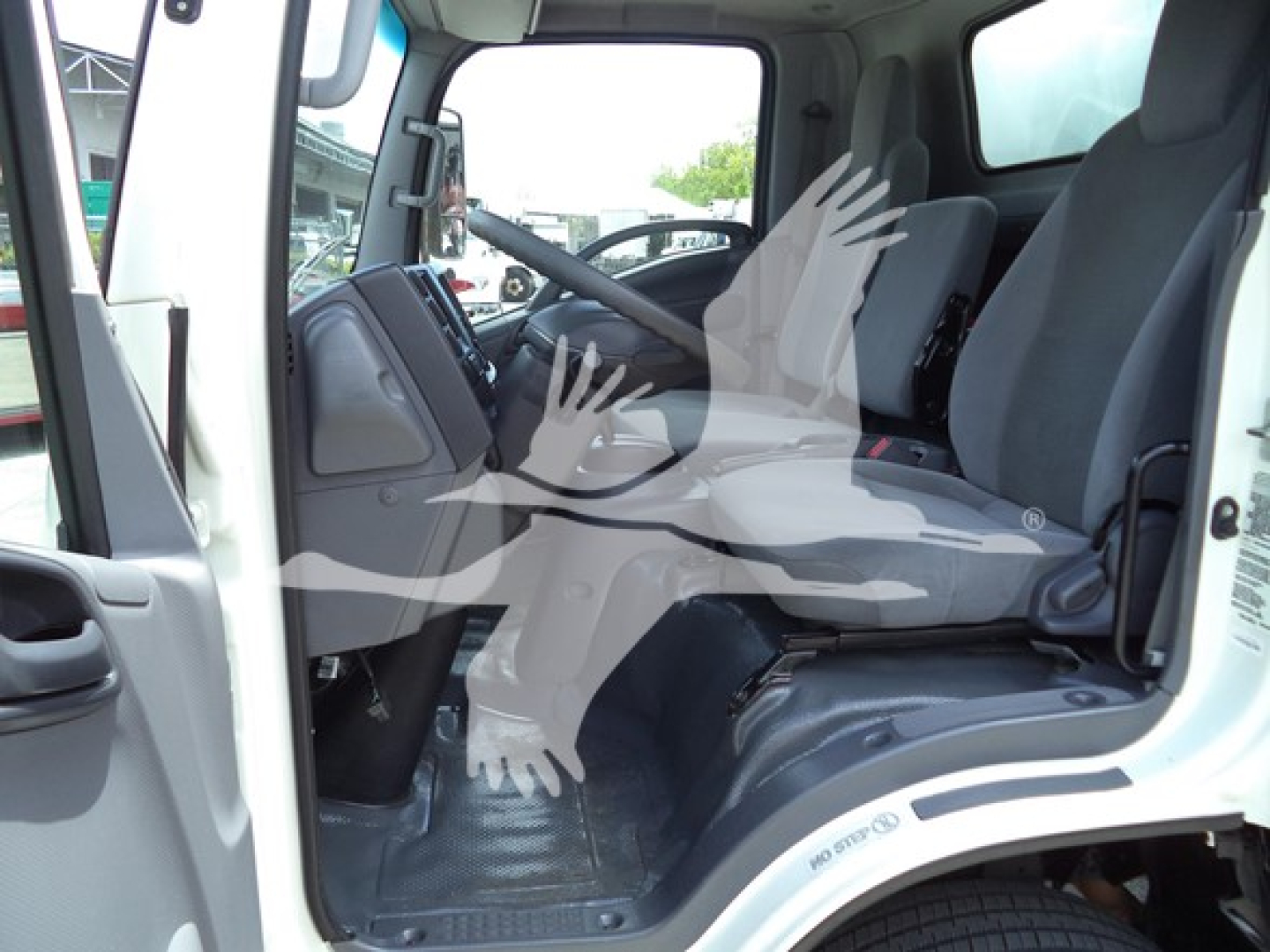 Isuzu NPR cab interior showing front seats and steering wheel in a left-hand drive truck.