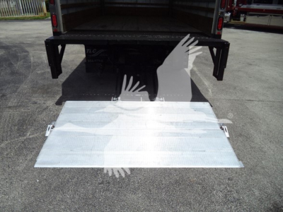 Isuzu NPR box truck rear view showing a lowered aluminum ramp and cargo area open.