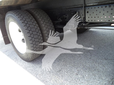 Isuzu NPR truck undercarriage showing dual rear wheels and chassis with DOT-type frame, tire tread visible.