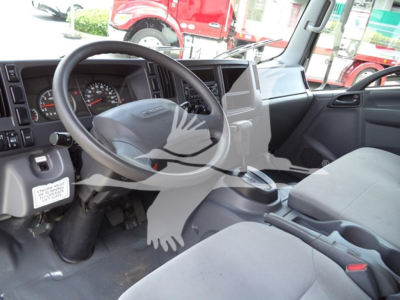 Isuzu NPR truck interior showing steering wheel, dashboard, and front seats with gear shifter; view through driver's side window.