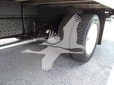 Isuzu NPR chassis undercarriage with dual rear wheels and visible exhaust/drive components.