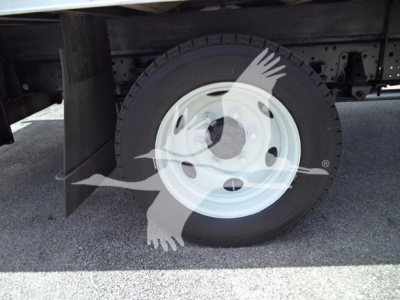 Isuzu NPR truck wheel and tire shown in side view, white steel rim, underbody area visible.
