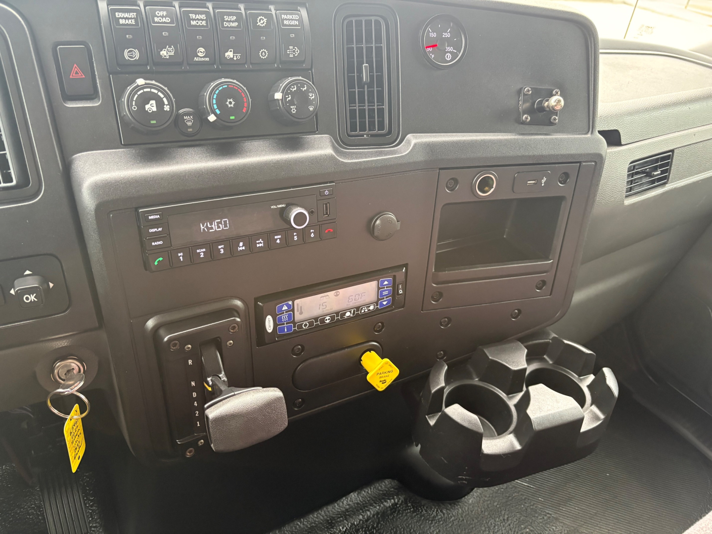Truck cab interior dashboard showing HVAC controls, stereo, and cup holders.