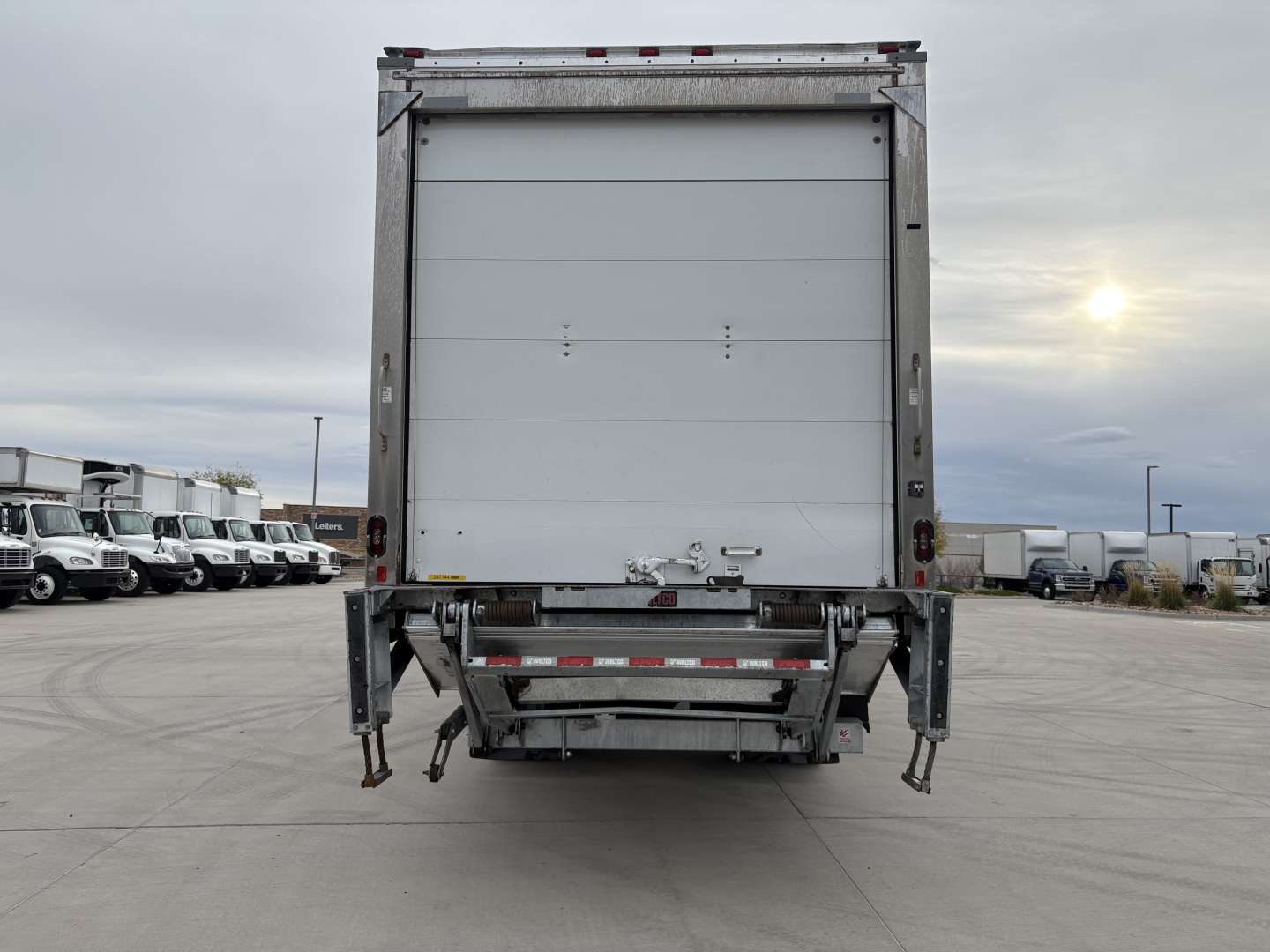 Truck rear view of a 2020 International MV607 refrigerated box truck showing a closed cargo door and rear underride guard.
