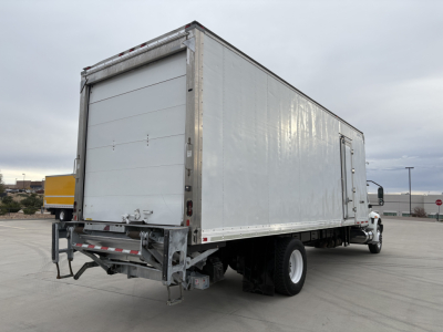 Truck rear and right side view of a 2020 International MV607 refrigerated box truck showing a large white cargo box with rear roll-up door and bumper.