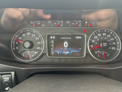 Dashboard of a 2020 International MV607 showing speedometer, tachometer, and center digital display; various gauges visible including RPM scale and fuel/engine indicators.