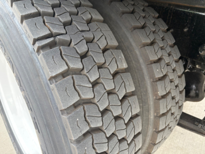 Truck rear dual tires with heavy tread on a refrigerated 2020 International MV607 showing dual tire ensemble and chassis components.