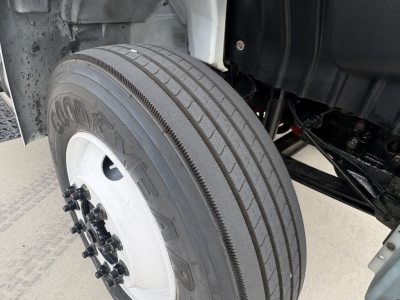 Wheel and front suspension of 2020 International MV607 refrigerated truck showing tire and wheel from a close-on view.