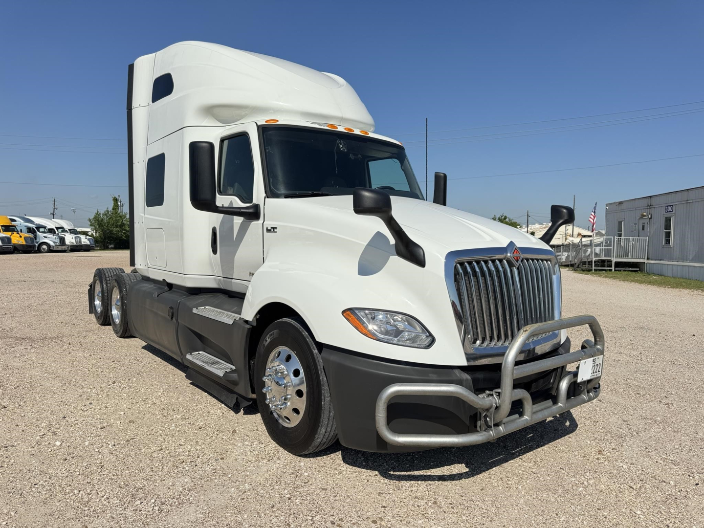 Truck cab of a white 2020 International LT sleeper tractor shown from front-left angle with grille guard and dual headlights.