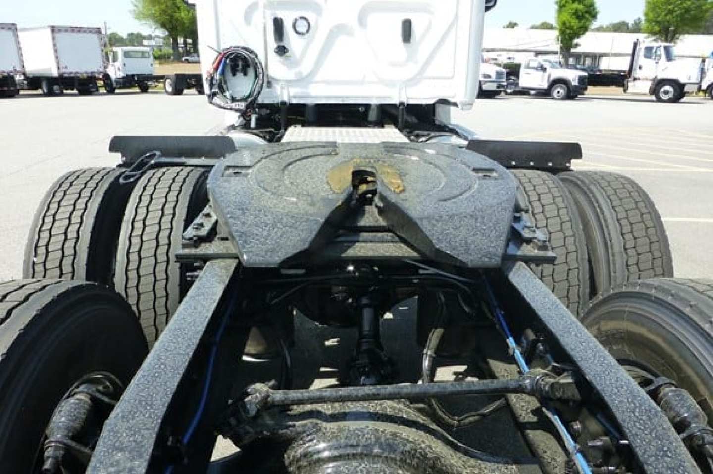 Truck chassis view from behind showing fifth wheel, dual rear axles, and fuel line plumbing.