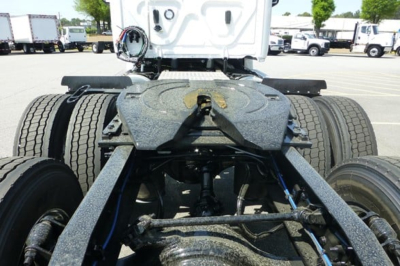 Truck chassis view from behind showing fifth wheel, dual rear axles, and fuel line plumbing.
