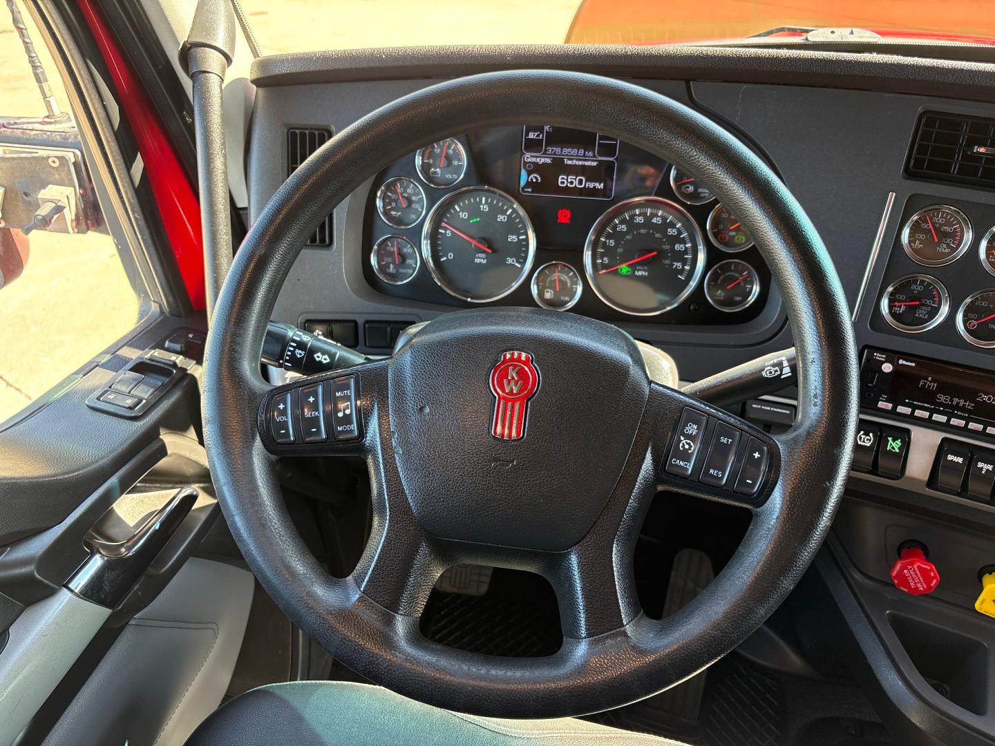 Kenworth T680 interior showing steering wheel, instrument cluster, and dashboard controls.