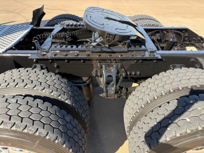 Kenworth T680 chassis showing fifth wheel and dual rear axles with tires, frame and hitch components visible.