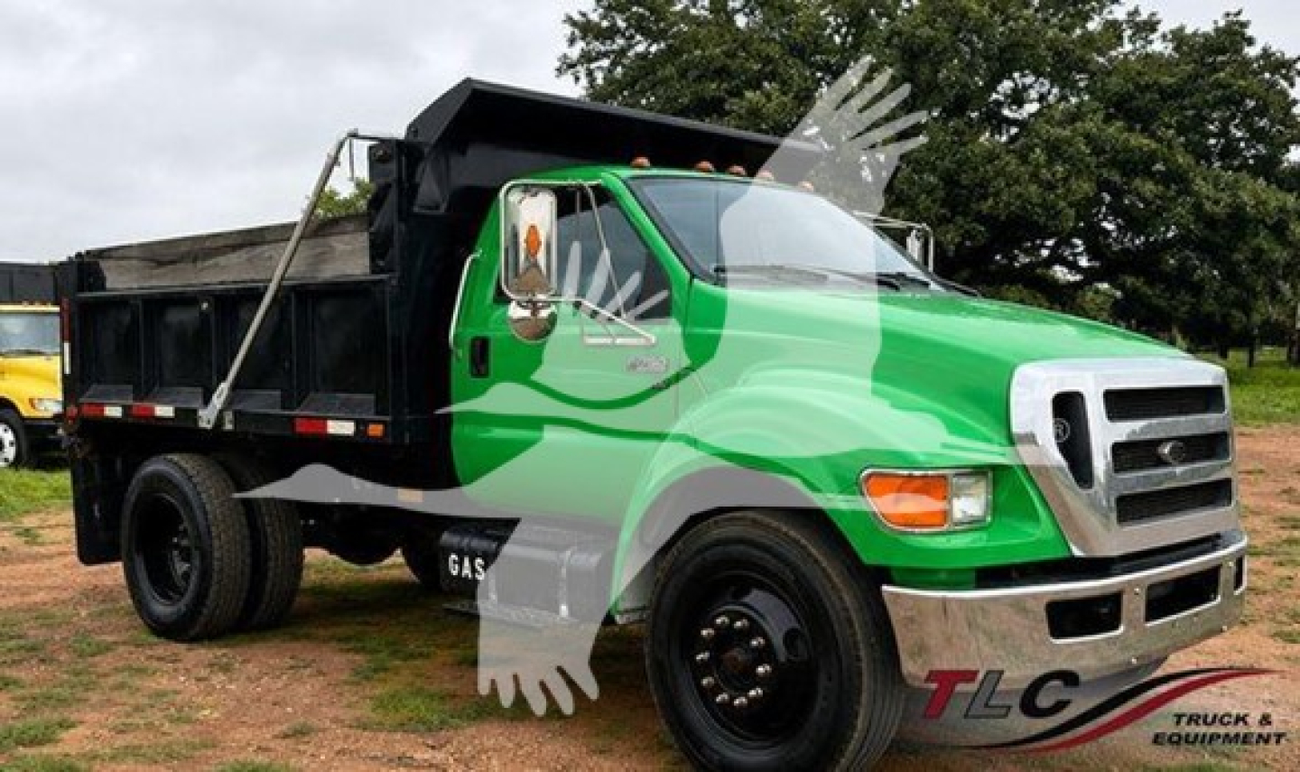 2013 Ford F650 dump truck side view showing green cab and black dump bed with TLC Truck & Equipment logo watermark