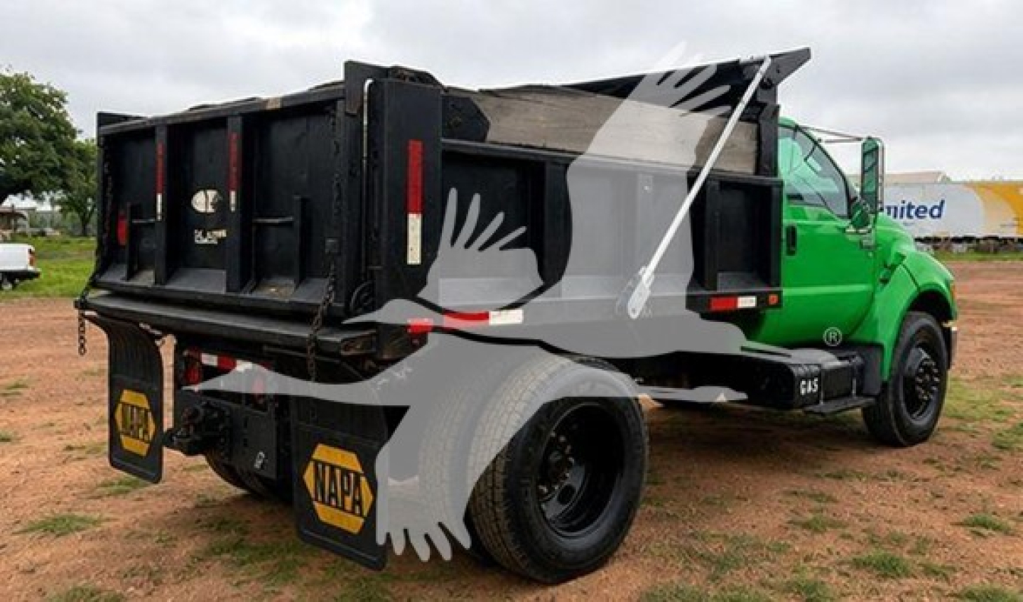 Ford F650 dump truck side/rear view showing black dump bed and green cab, NAPA mudflaps, VIN tag area not legible.