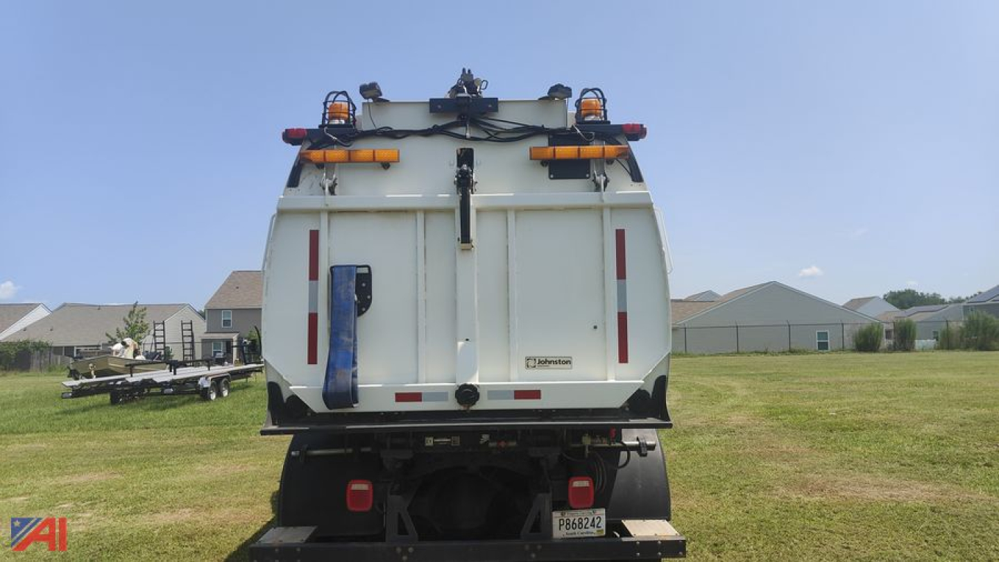 Rear view of a white Freightliner M2 106 sweeper/vac truck with safety lights and rear access doors.