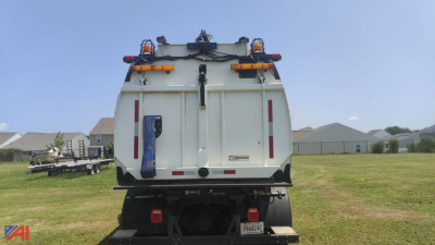 Rear view of a white Freightliner M2 106 sweeper/vac truck with safety lights and rear access doors.