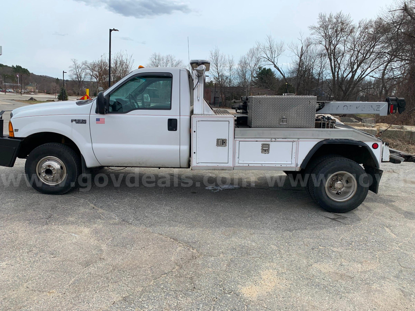 1999 Ford F-350 tow truck side view showing utility storage boxes and diamond-plate toolbox.