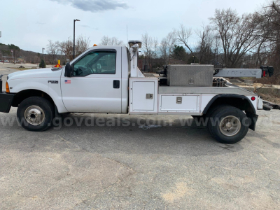 1999 Ford F-350 tow truck side view showing utility storage boxes and diamond-plate toolbox.
