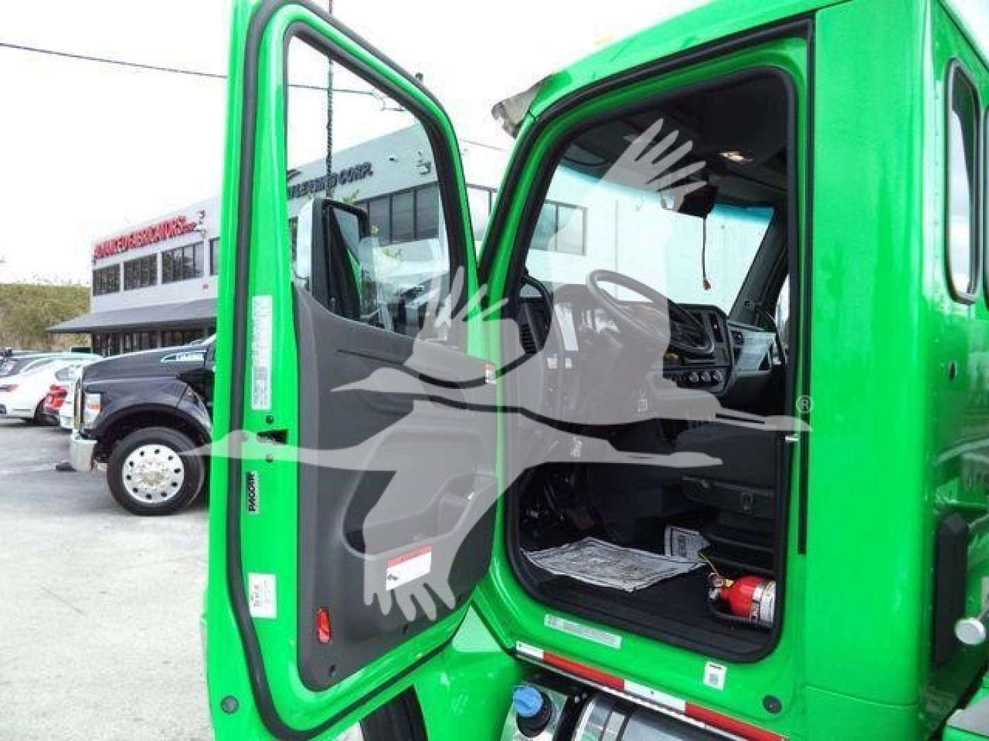 Peterbilt 536 cab interior visible through open driver door; green truck with black interior, dashboard and steering wheel visible