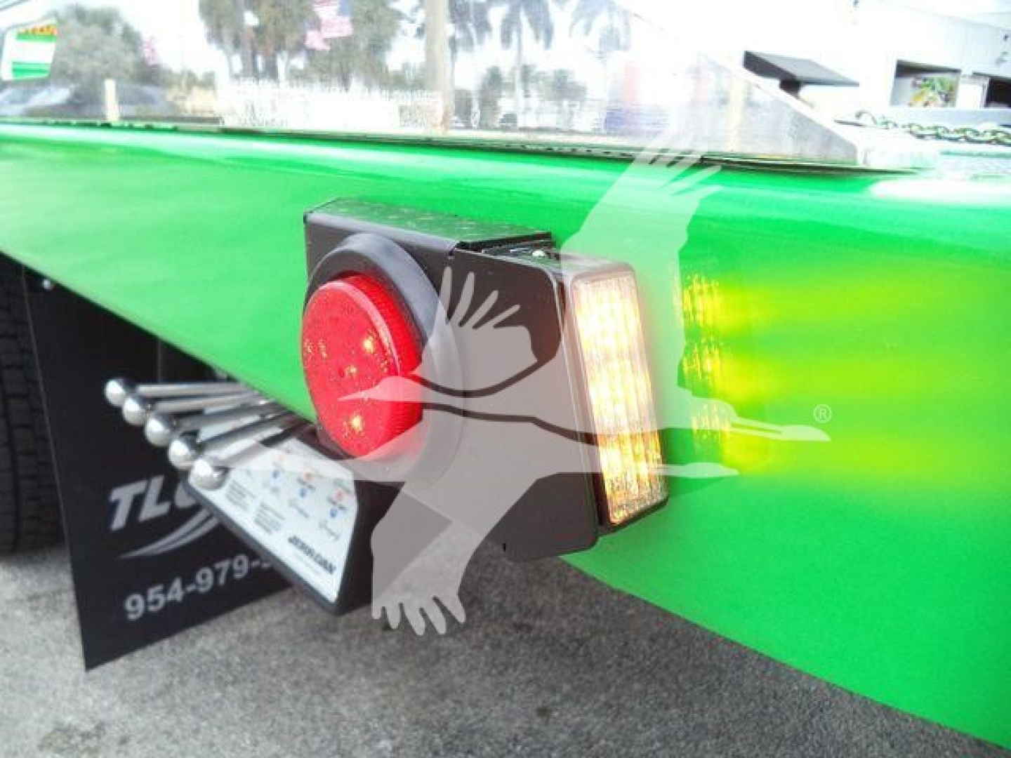 Green Peterbilt 536 truck rear bumper with red circular taillight and rectangular amber indicator light.
