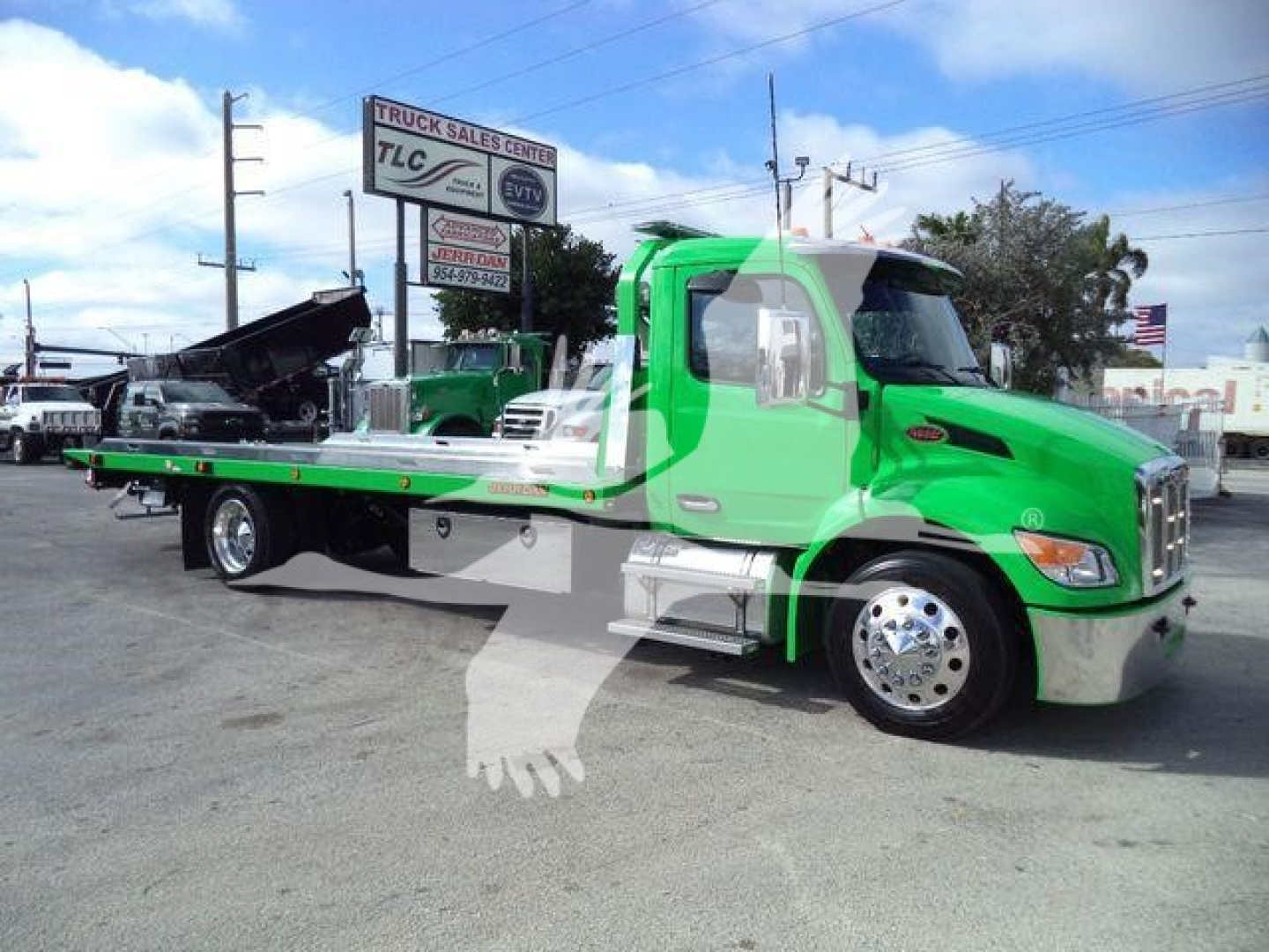Peterbilt 536 rollback tow truck in bright green with flatbed and hydraulic winch, side mirrors, chrome bumper, and front grille visible.