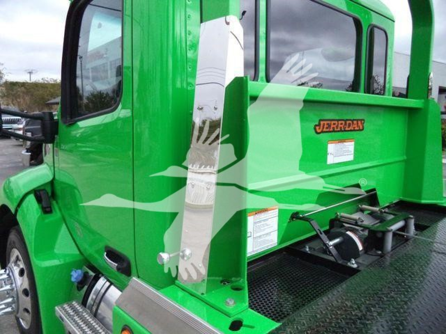 Peterbilt 536 rollback truck showing green cab and Jerr-Dan branding on rear panel with side steps and decals.