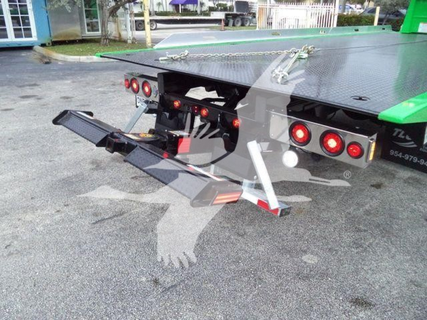 Rear view of a new Peterbilt 536 rollback truck showing towing controls, dual rear bumper setup, and hydraulic flatbed with green accents.