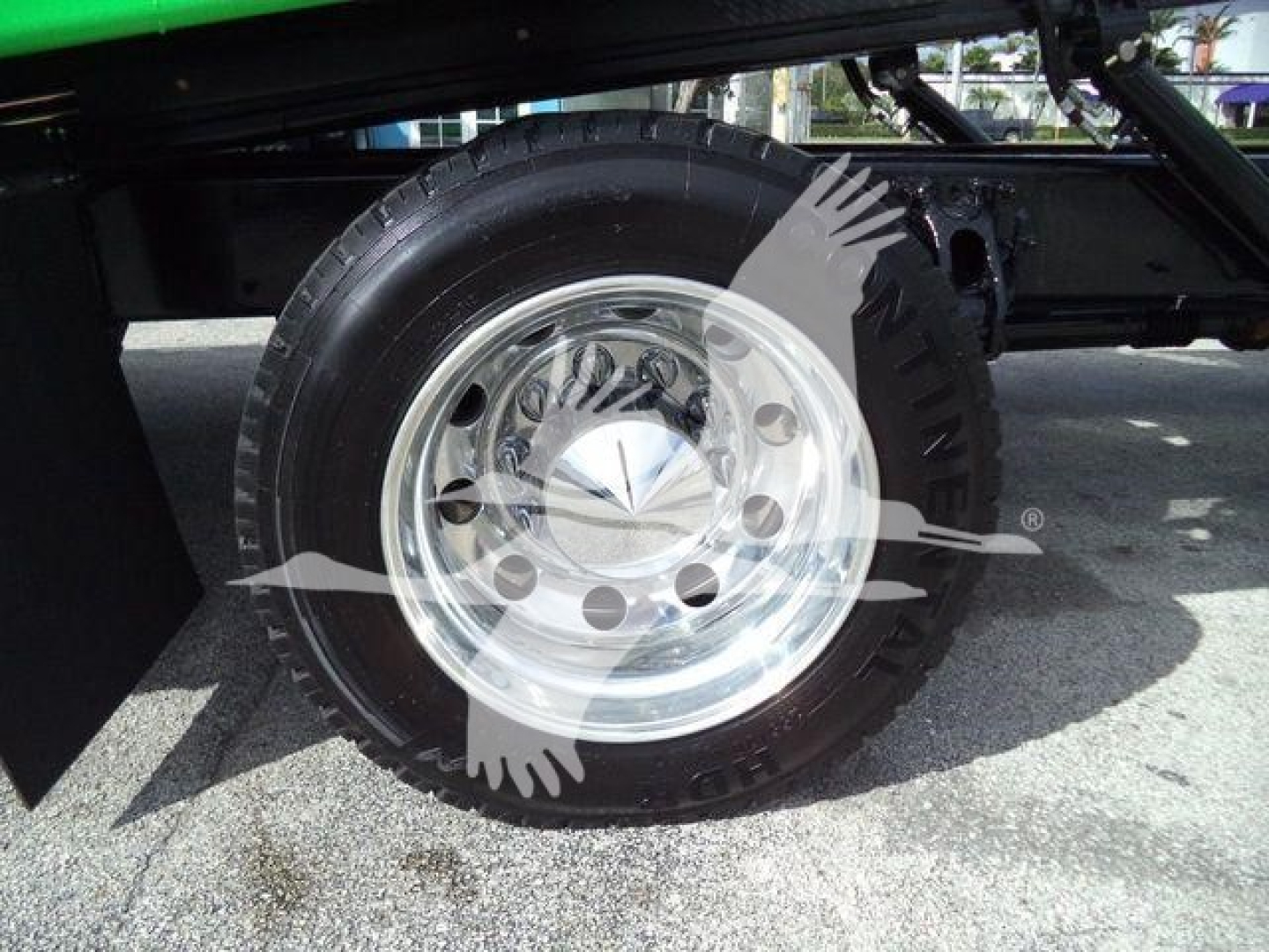 Peterbilt 536 rollback truck wheel and chrome rim with tire, side view in service lot.