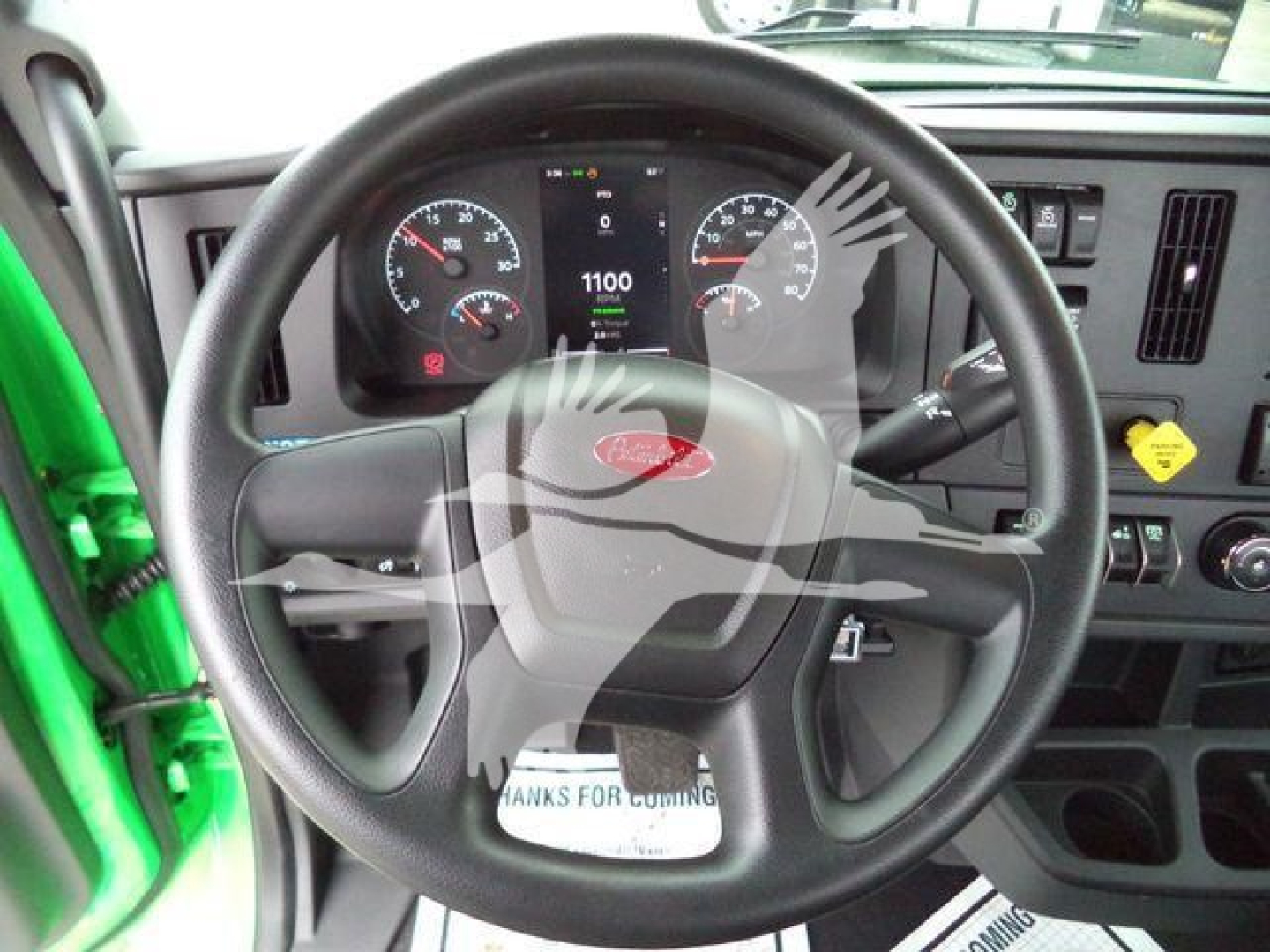 Steering wheel and dashboard of a new 2026 Peterbilt 536 roll-back truck, showing digital gauge cluster and instrument panel.