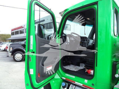 Peterbilt 536 cab interior visible through open driver door; green truck with black interior, dashboard and steering wheel visible