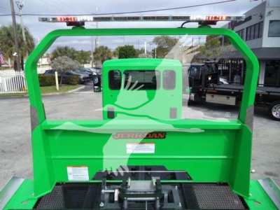 Green Peterbilt 536 rollback bed with rear cab and Jerr-Dan branding, showing hydraulic system area and loading bed.