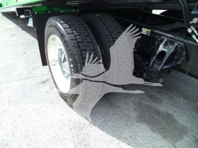 Peterbilt 536 rollback truck rear dual wheels and chassis view showing tires and undercarriage with green equipment above.