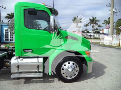 Peterbilt 536 side view showing bright green color with chrome fuel tanks and wheel, cab window, and side graphic on the door.