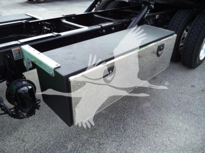 Toolbox mounted on a Peterbilt truck frame showing a metal storage box with two handles and side cutouts.