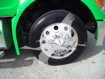 Truck wheel and green fender of a Peterbilt 536 rollback truck showing polished chrome wheel with lug nuts.