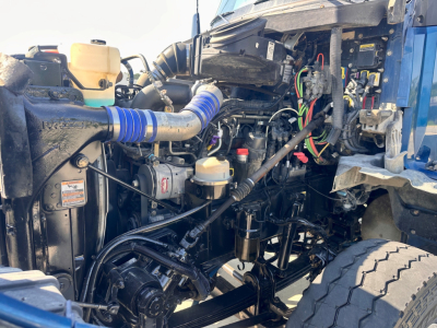 Kenworth T880 engine bay and front chassis with hoses, wiring, and coolant reservoir visible.