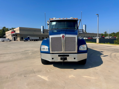 Kenworth T880 front view showing large chrome grille, bumper, and dual rectangular headlights. Cab mirrors extend from sides; hood ornament and slim bumper winch area visible.