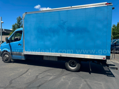 Box truck side view showing Freightliner Sprinter cargo box with blue color and wheels visible.