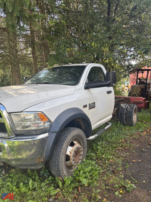 Ram 5500 cab and chassis truck with plow; white two-door cabin, dual rear wheels removed, side step, side mirrors, large front bumper.