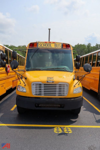 Front view of a yellow 2016 Freightliner Thomas Saf-T-Liner school bus with 320 emblem on the hood, 'SCHOOL BUS' sign, and side mirrors flanking the grille.