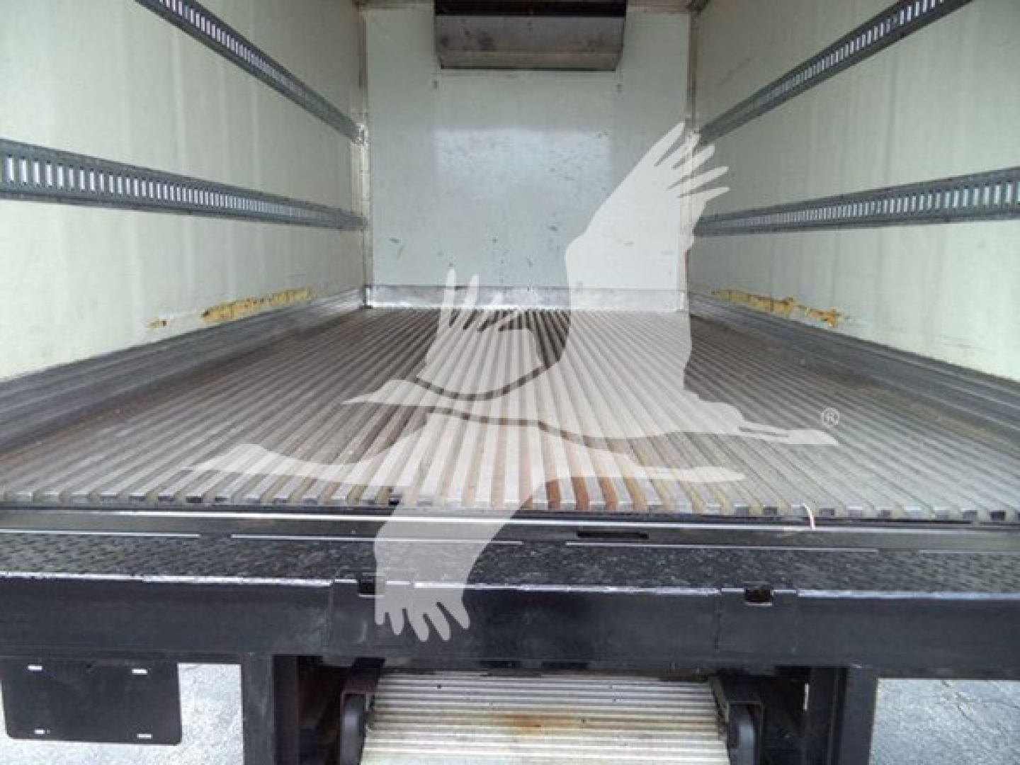 Truck cargo area of a 2020 Hino 195 refrigerated truck showing empty metal floor and side rails.