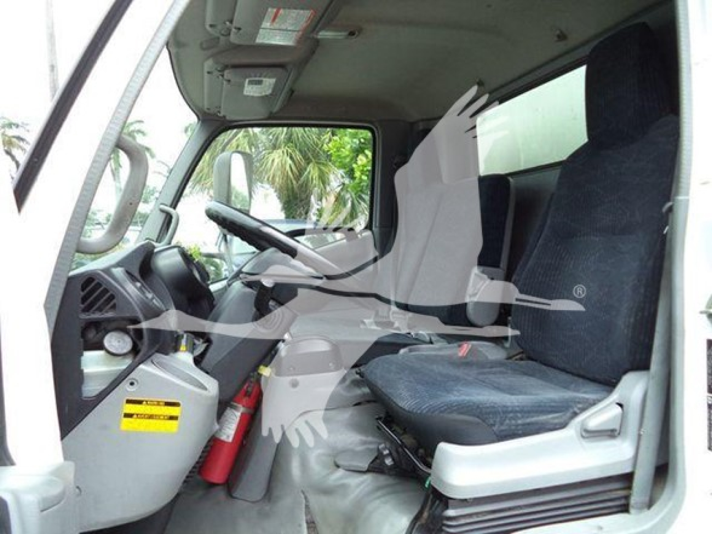Cab interior of a 2020 Hino 195 refrigerated truck showing driver seat and passenger seat, steering wheel, dashboard, and fire extinguisher.