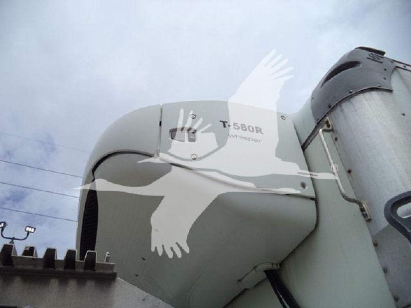 Front-left cab view of a 2020 Hino 195 refrigerated truck with T-580R label and curved sleeper window, showing side of hood and part of refrigeration unit.