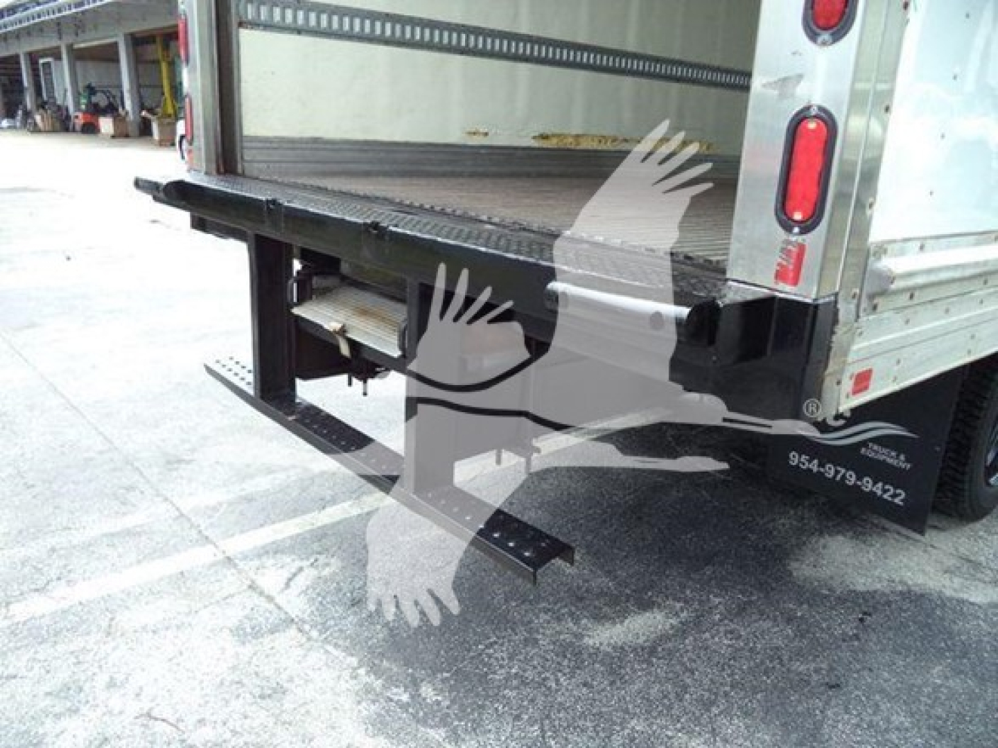 Back of a 2020 Hino 195 refrigerated truck showing rear cargo area and fold-down step/bumper with taillights.