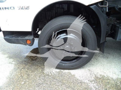 Front right wheel and fender of a 2020 Hino 195 refrigerated truck showing wheel well and partial front bumper; visible text 'HINO 195' on the side.