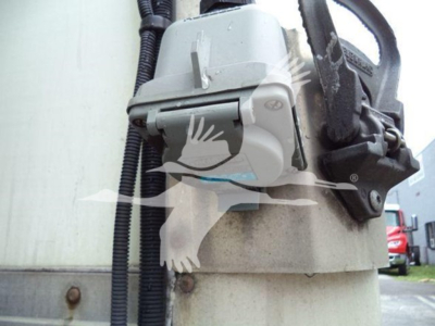 Refrigerated truck engine bay component showing a gray hydraulic valve or latch assembly mounted on a beige supporting post.