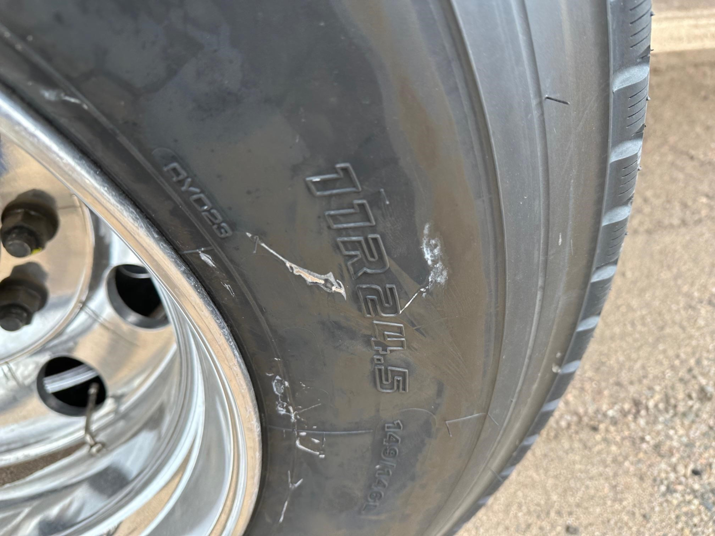 Tire sidewall of a 2026 Mac light weight aluminum end dump trailer showing VIKING? or MICHELIN? Details include 'TRAILER' script and alloy wheel; close-up of tire with tread and polished rim.