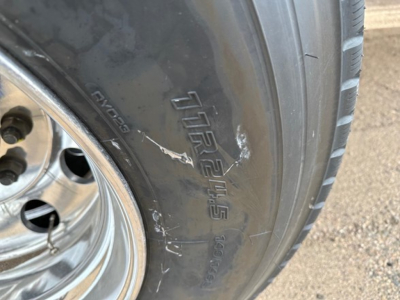 Mac Western light weight aluminum end dump trailer tire and wheel with tire brand and model markings visible.