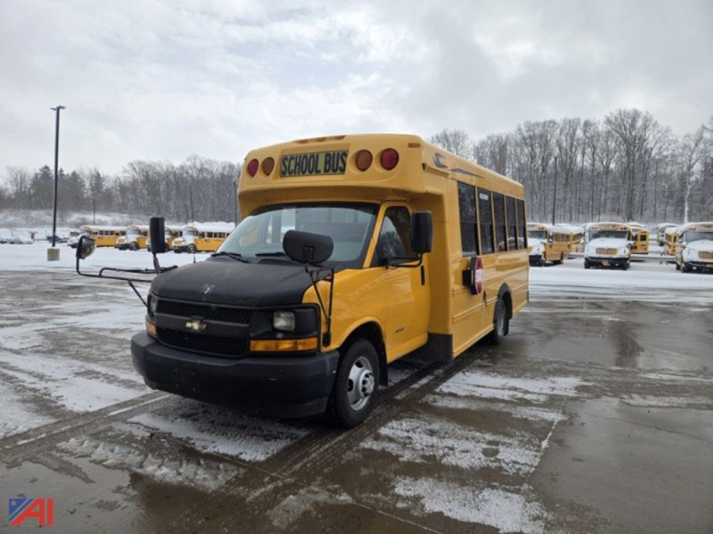 Bus front-left view of a yellow 2017 Chevrolet Express G4500 school bus with 'SCHOOL BUS' sign on top and snow on the ground.